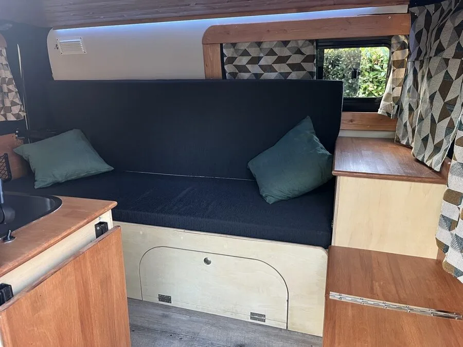 Intérieur de Peggy : banquette, coussins, plans de travail et rangements en bois