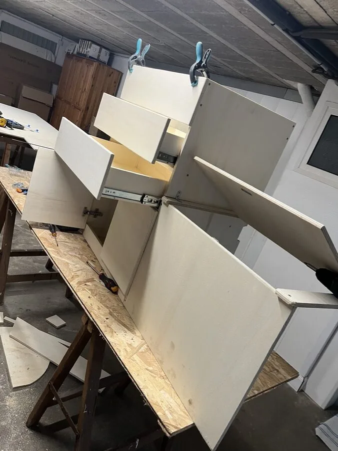Meuble à tiroirs en cours d'assemblage sur un établi de l'atelier